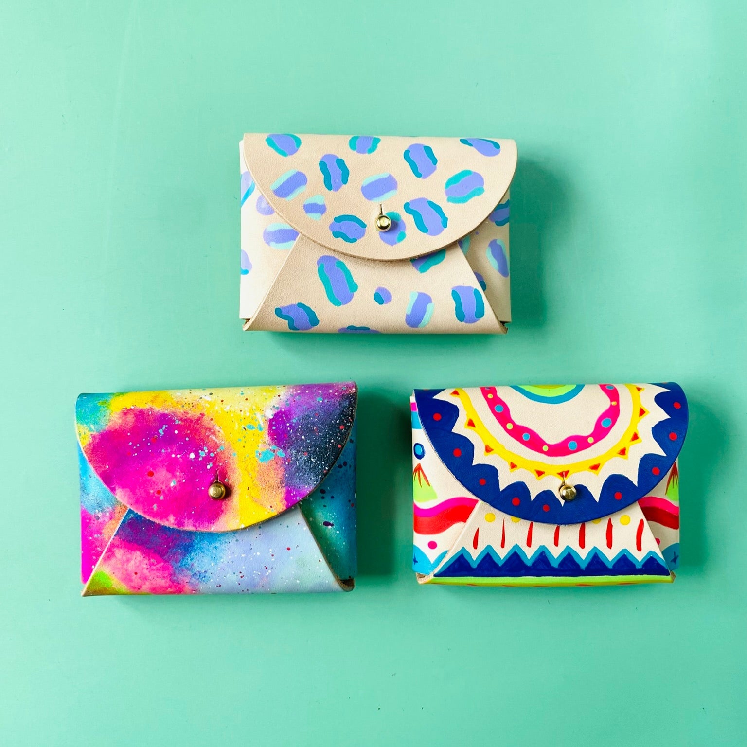 Three colorful envelopes with different patterns on a green background