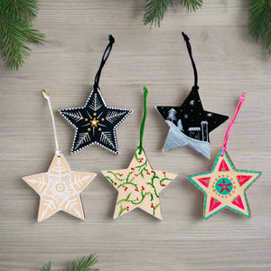 Five star-shaped Christmas ornaments on a white background
